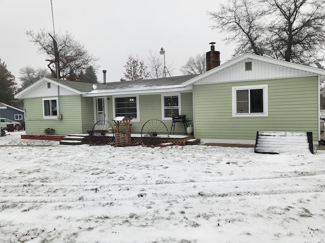 view of snow covered rear of property