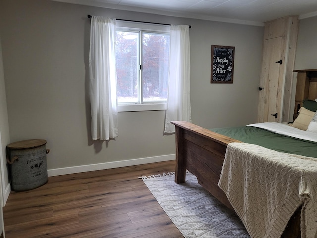 bedroom featuring crown molding and dark hardwood / wood-style flooring