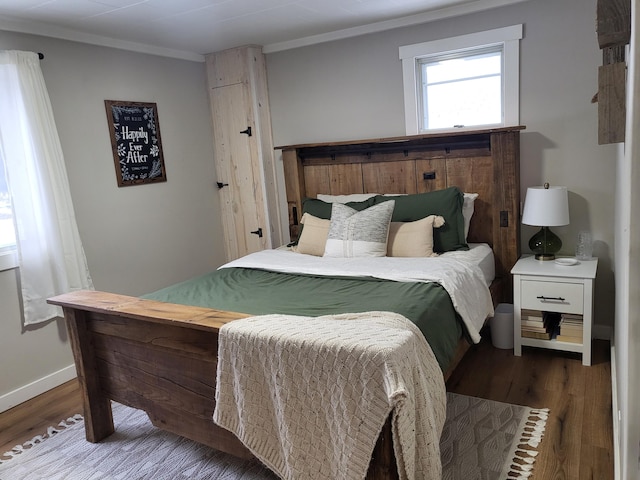 bedroom with wood-type flooring and crown molding