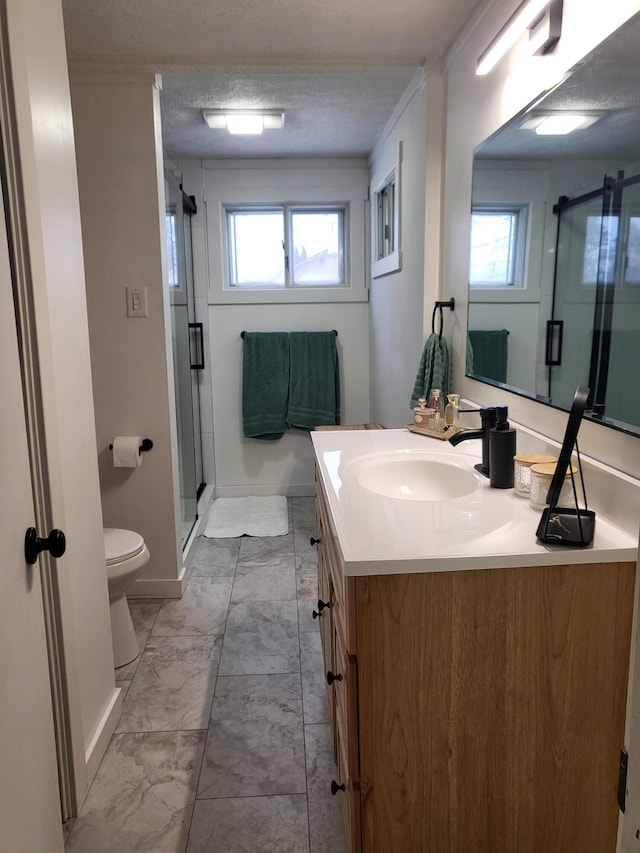 bathroom featuring a textured ceiling, vanity, a shower with door, and plenty of natural light