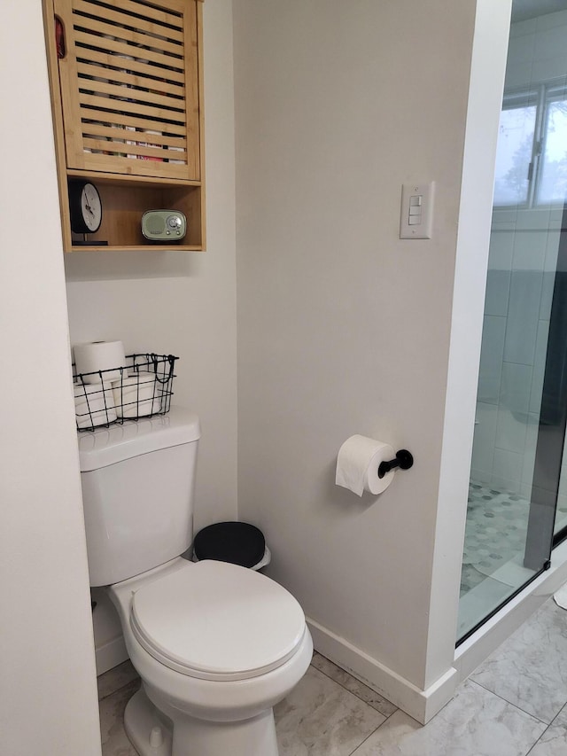 bathroom with a shower with shower door and toilet