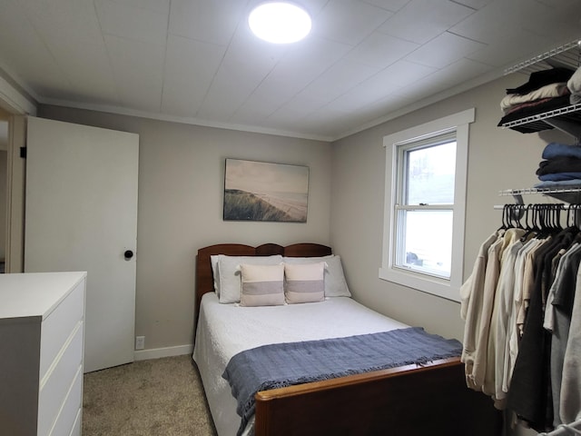 bedroom with light colored carpet and crown molding