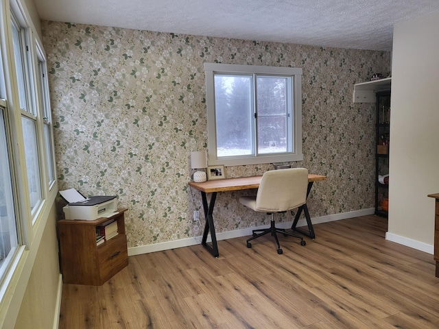 home office featuring wood-type flooring and a textured ceiling