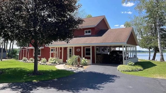 view of front of property with a water view, a carport, and a front lawn