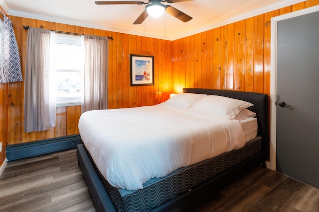 bedroom with baseboard heating, ceiling fan, crown molding, and dark hardwood / wood-style flooring