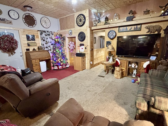 carpeted living room with wood walls