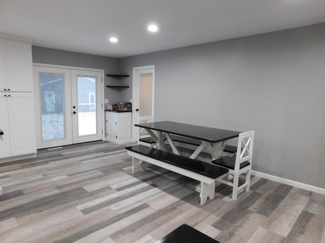 dining room with french doors and light hardwood / wood-style flooring