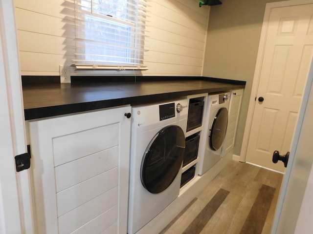 clothes washing area featuring washer and clothes dryer and light wood-type flooring