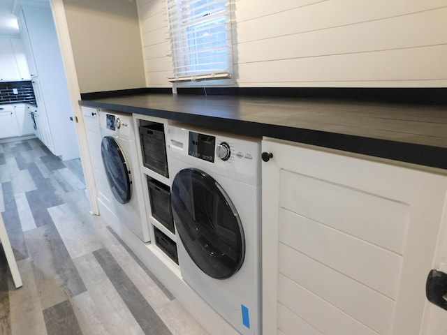 laundry room with washing machine and dryer and light hardwood / wood-style flooring