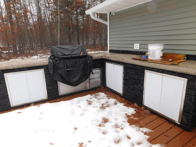 snow covered patio with area for grilling