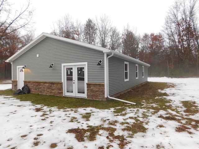 view of snow covered exterior with french doors