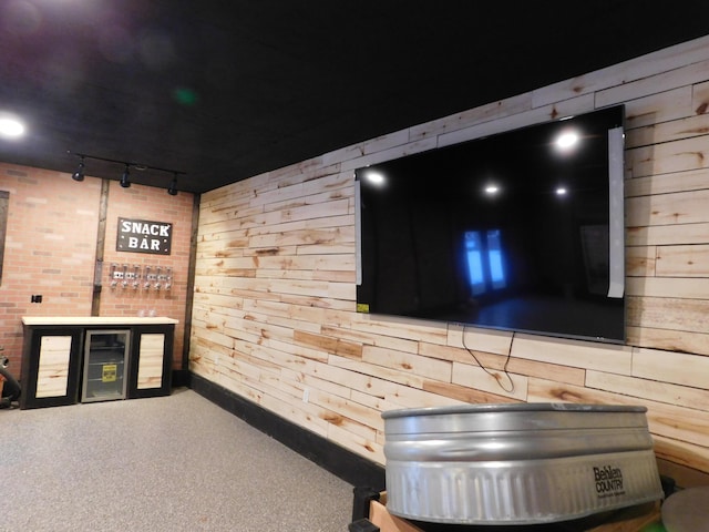 bar with carpet flooring, wood walls, and track lighting