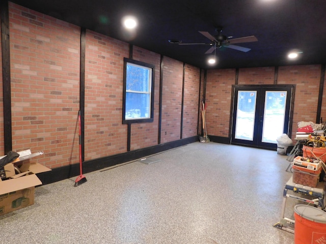 spare room with ceiling fan, brick wall, and french doors