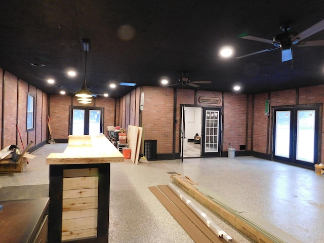 interior space with butcher block countertops, pendant lighting, french doors, and brick wall