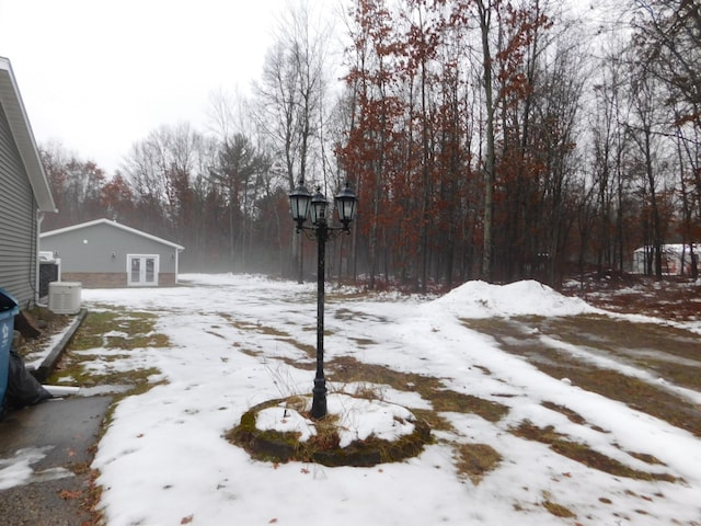 snowy yard featuring cooling unit and french doors