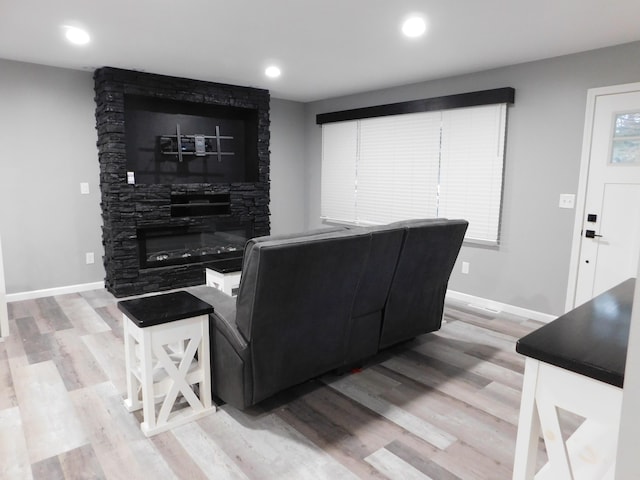 living room with a fireplace and light wood-type flooring