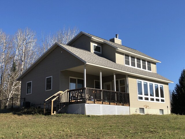 back of property with a porch and a yard