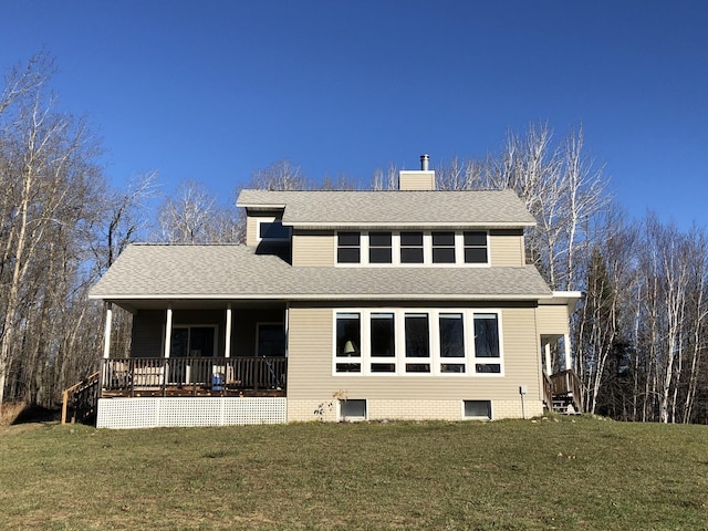 rear view of property featuring a porch and a lawn