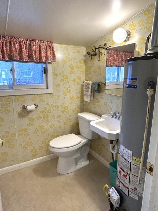 bathroom featuring gas water heater, toilet, and sink