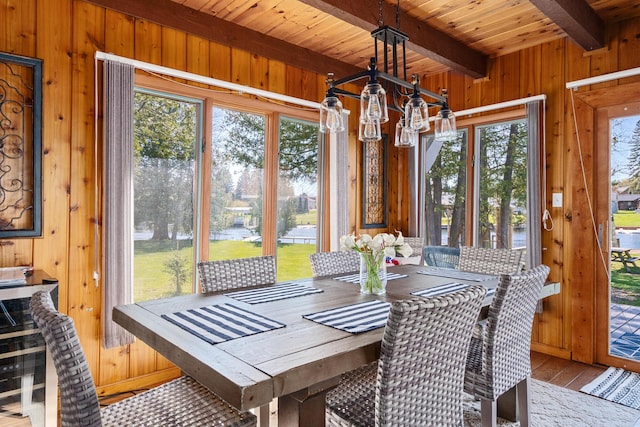 sunroom / solarium with beamed ceiling, wooden ceiling, a healthy amount of sunlight, and a notable chandelier