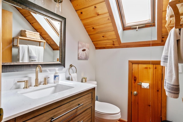 bathroom featuring vaulted ceiling with skylight, vanity, wood ceiling, and toilet