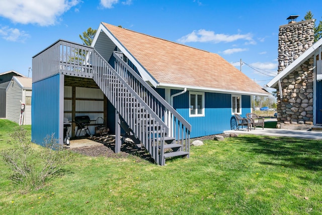 rear view of house featuring a wooden deck, a patio area, and a yard