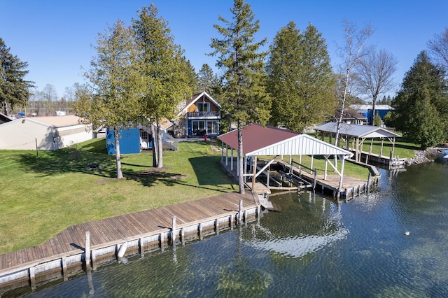 view of dock with a lawn and a water view