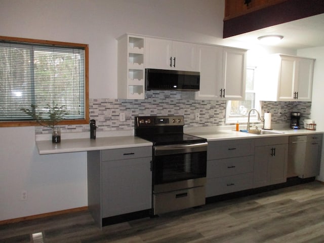 kitchen featuring tasteful backsplash, stainless steel electric stove, a wealth of natural light, white cabinets, and sink