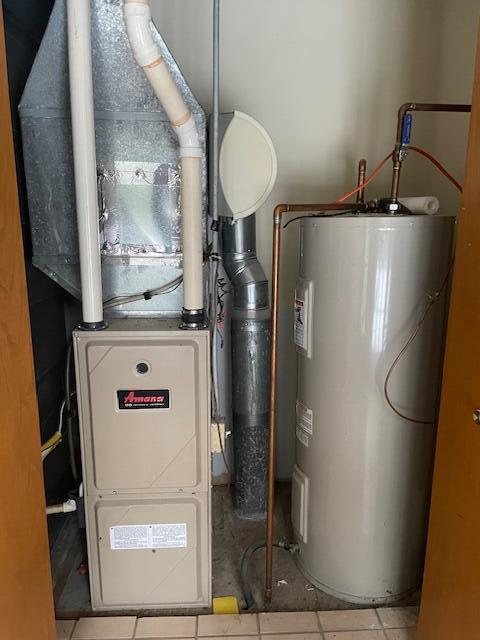 utility room with heating unit and water heater