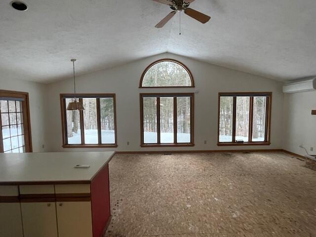 unfurnished living room featuring a wall mounted AC, a textured ceiling, ceiling fan, and lofted ceiling