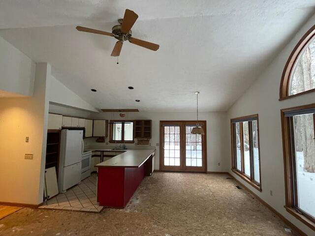 kitchen with white refrigerator, a healthy amount of sunlight, and vaulted ceiling