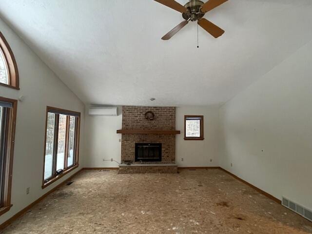 unfurnished living room with ceiling fan, a fireplace, a wall mounted air conditioner, and vaulted ceiling