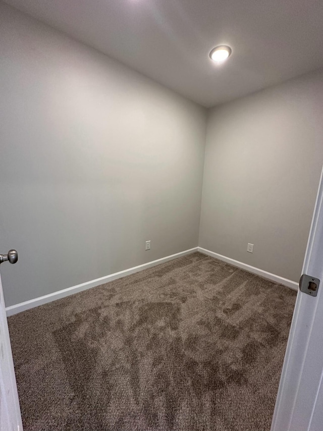 spare room with dark carpet