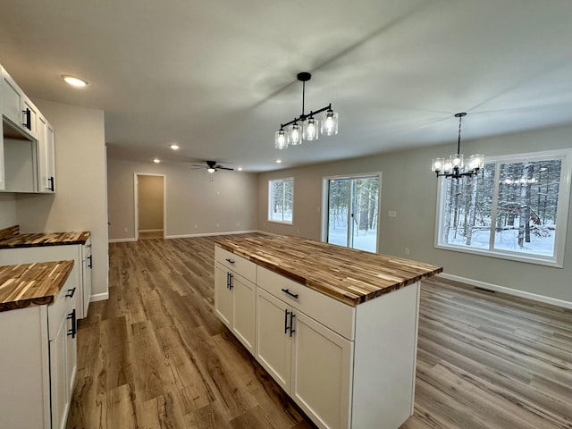 kitchen featuring white cabinets, wood counters, and pendant lighting