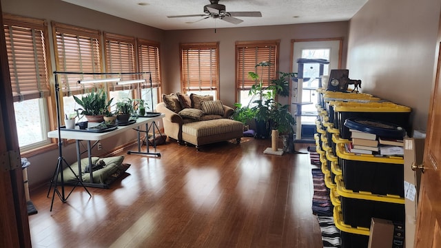 living area with a textured ceiling, a ceiling fan, and hardwood / wood-style floors