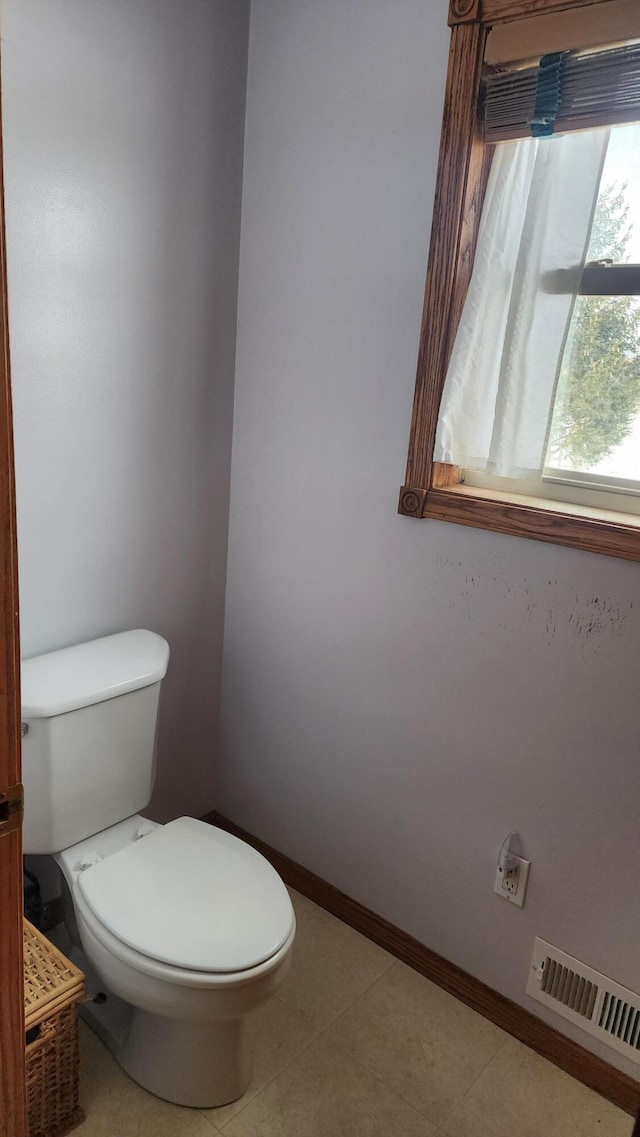 bathroom featuring baseboards, visible vents, and toilet