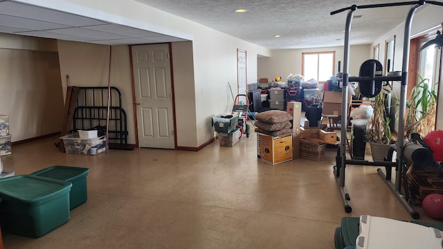 below grade area with a textured ceiling and baseboards