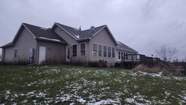 snow covered property with a shingled roof, stairs, a lawn, and a wooden deck