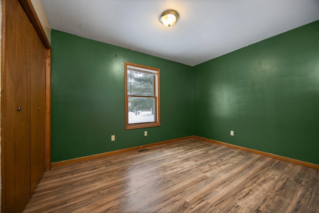 unfurnished bedroom with hardwood / wood-style floors and a closet