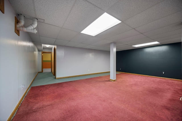 basement with a paneled ceiling and carpet