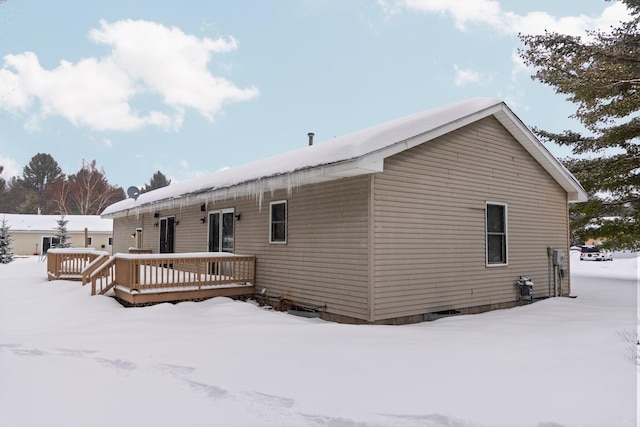 snow covered house featuring a deck