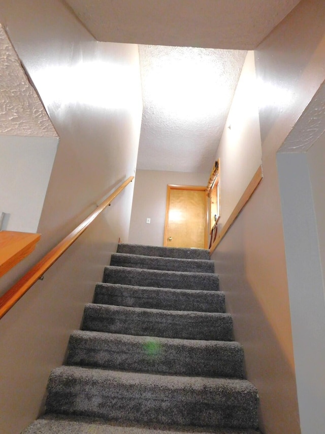 staircase with a textured ceiling