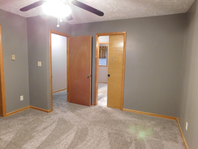 unfurnished bedroom with light carpet, a textured ceiling, and ceiling fan