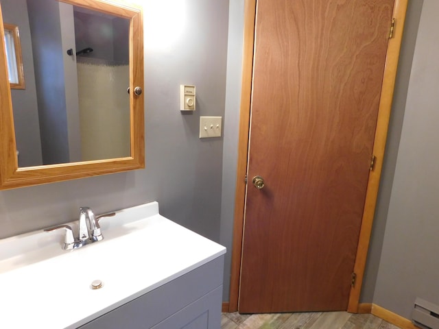 bathroom featuring hardwood / wood-style flooring, vanity, and a baseboard radiator