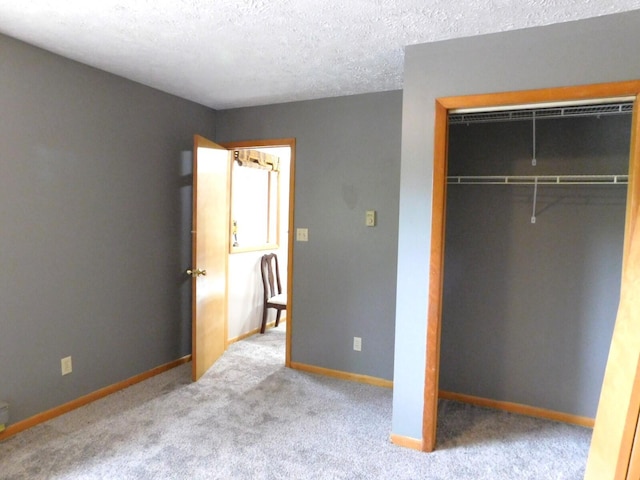 unfurnished bedroom with a textured ceiling, light carpet, and a closet