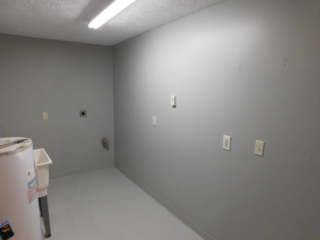 clothes washing area with electric dryer hookup, electric water heater, and a textured ceiling