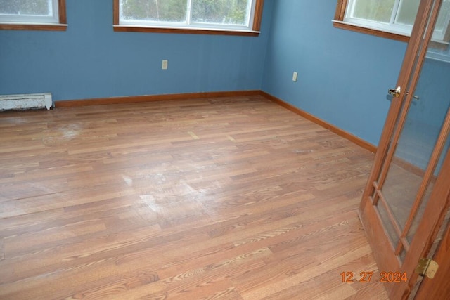 unfurnished room with light hardwood / wood-style floors and a baseboard radiator