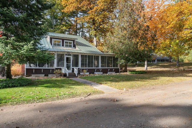 view of front facade with a front yard and a sunroom