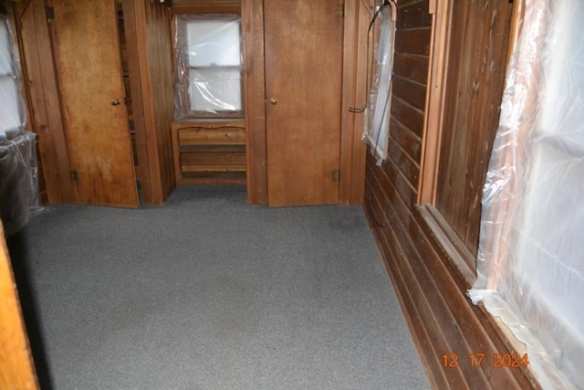 hallway with dark colored carpet