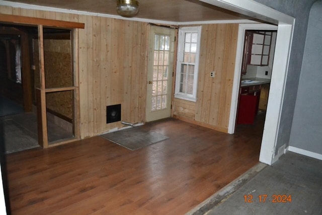 unfurnished room with a fireplace, dark hardwood / wood-style floors, and wood walls